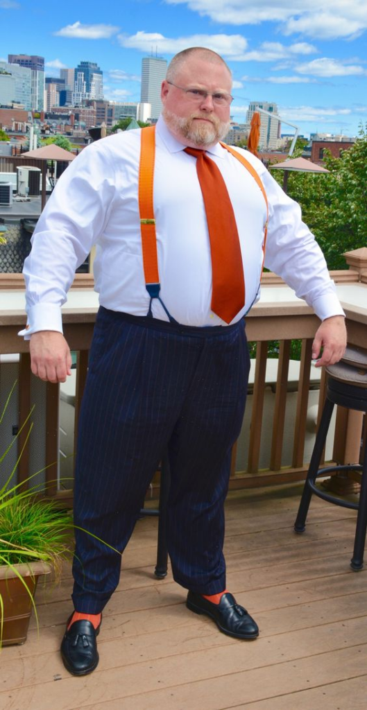 Fat man wearing orange color suspenders which we is reviewed as one of the best suspenders for fat guys/men